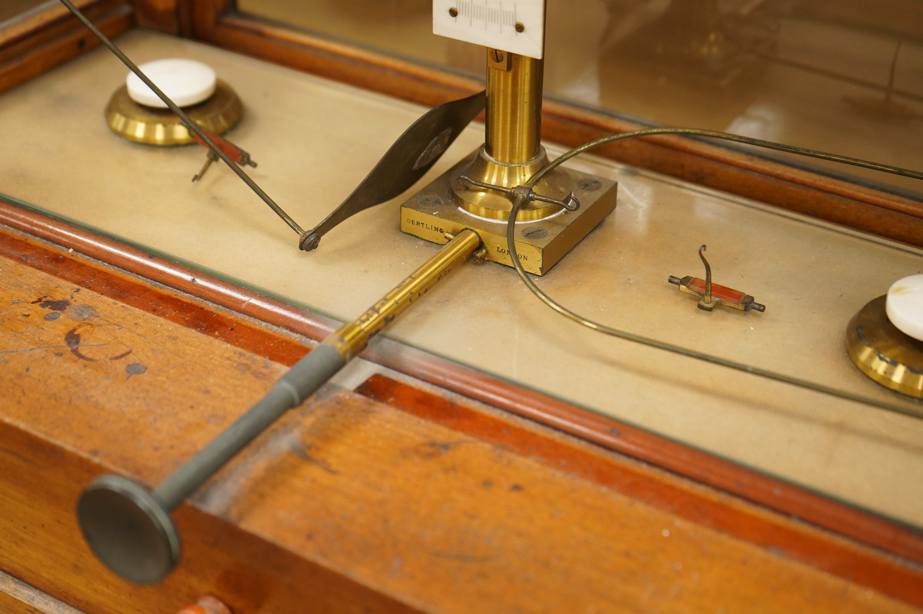 An early 20th century glazed mahogany cased laboratory chemical balance by Oertling, London, the drawer housing a set of weights, 45.5cm high, 50cm wide, 26cm deep